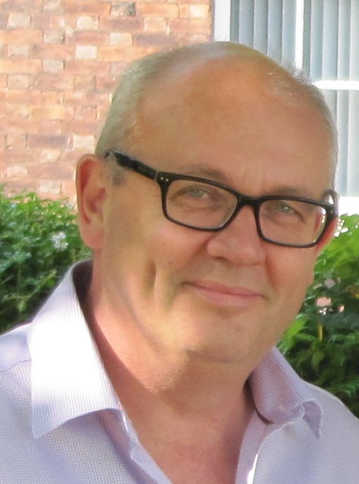 Portrait of Paul Gerrard wearing glasses and a light shirt outdoors