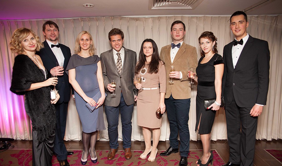 Eight attendees posing together at a formal awards event reception