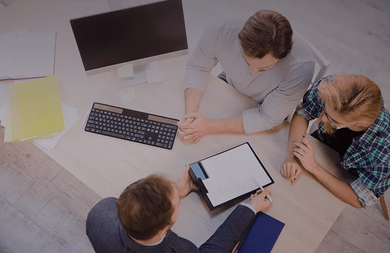Top view of consultants discussing document and recommendations at an office desk