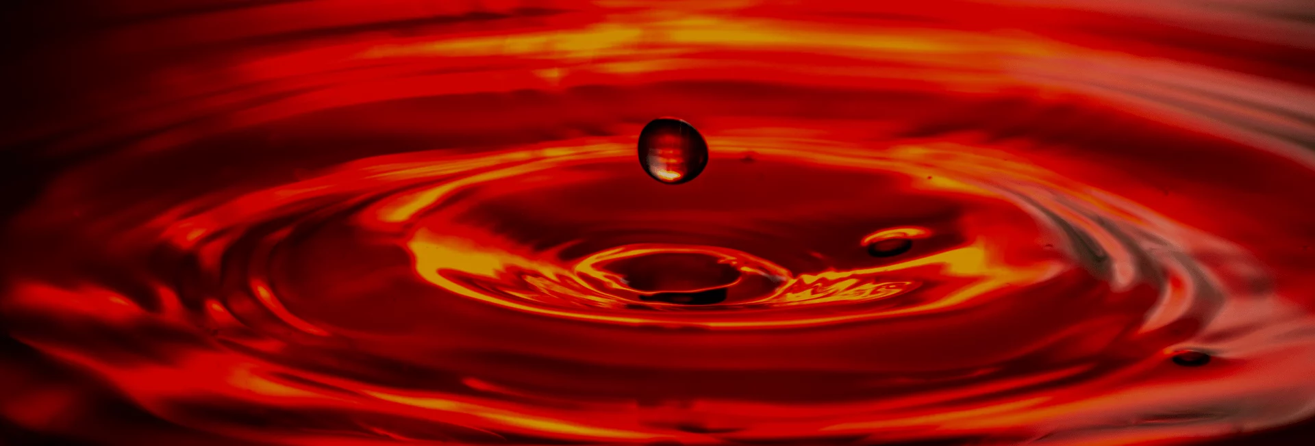 Red liquid droplet creating ripples, symbolizing continuous testing cycles and rapid feedback