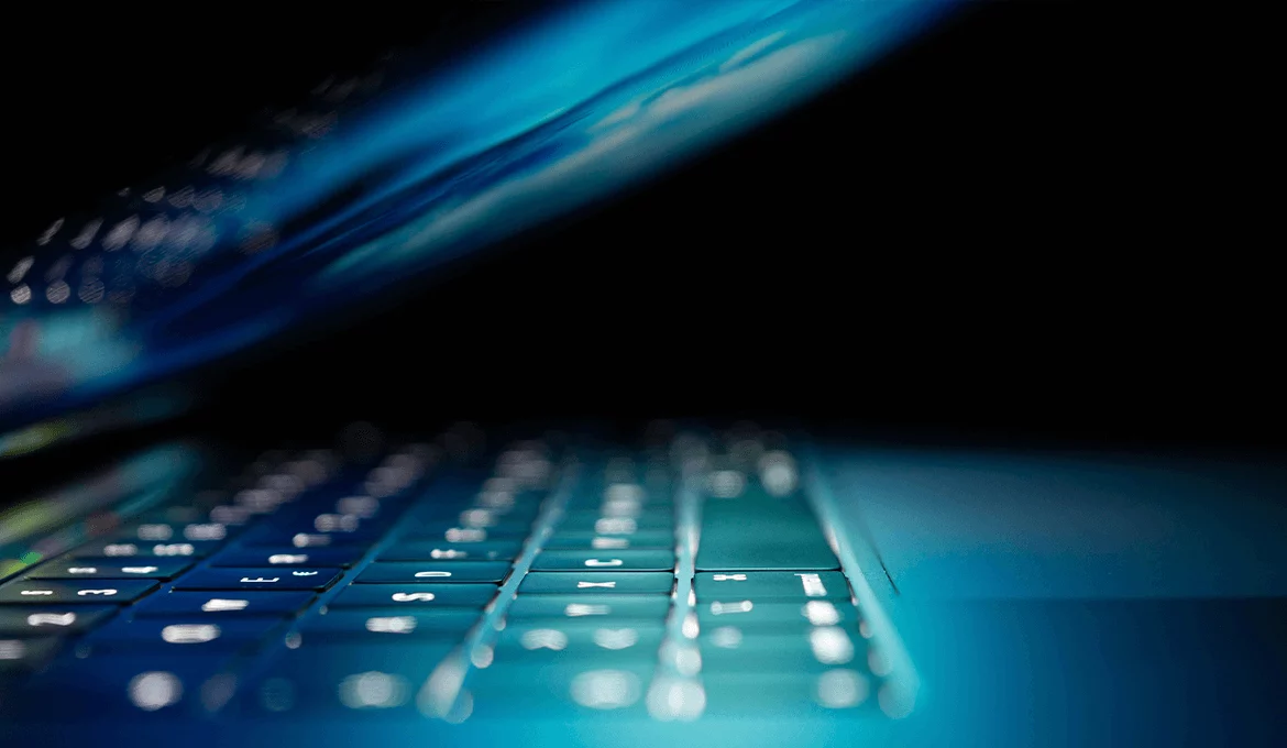 Close-up of a laptop keyboard in blue light, representing cybersecurity testing services