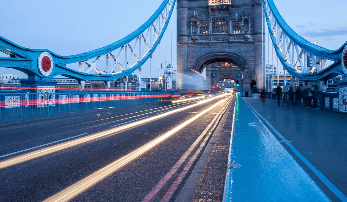 Light trails across Tower Bridge at dusk symbolizing speed and high performance