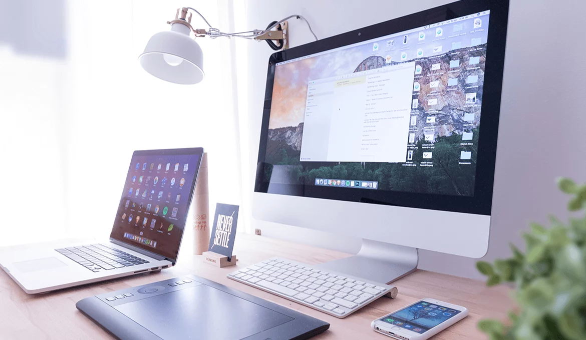 Modern software testing workspace with desktop, laptop, drawing tablet, and mobile phone