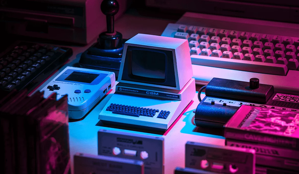 Retro gaming devices and a Commodore CBM Model 8032 on a desk under neon lighting