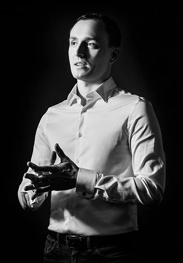 Black-and-white portrait of a business professional speaking and gesturing during a presentation