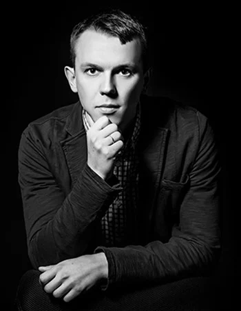 Black-and-white portrait of a thoughtful mobile testing specialist with hand on chin
