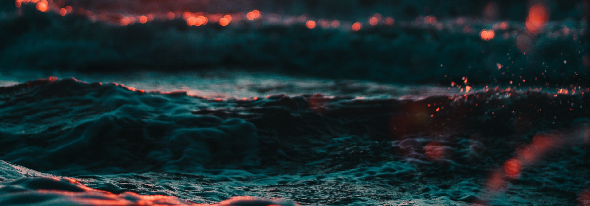 Abstract close-up of dark waves with glowing highlights, representing live production environment