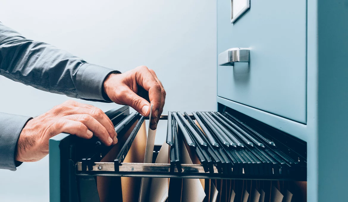 Hands organizing folders in a filing cabinet, representing structured integration testing processes