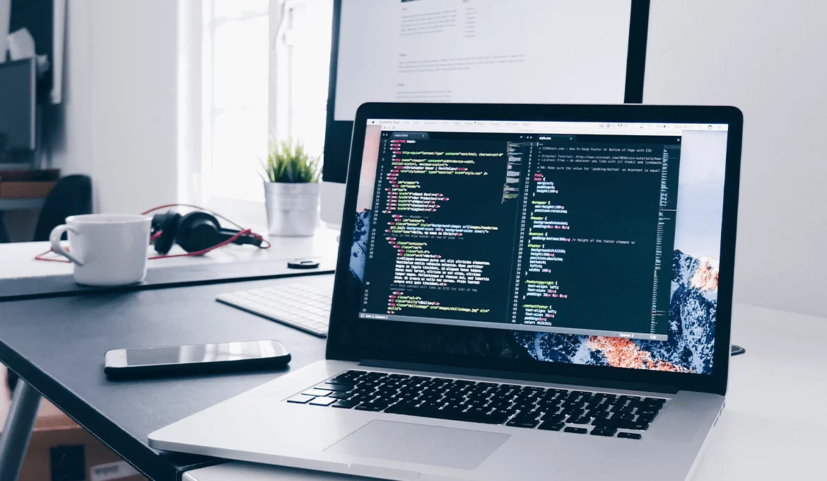 Laptop displaying code on a desk in a software testing workspace