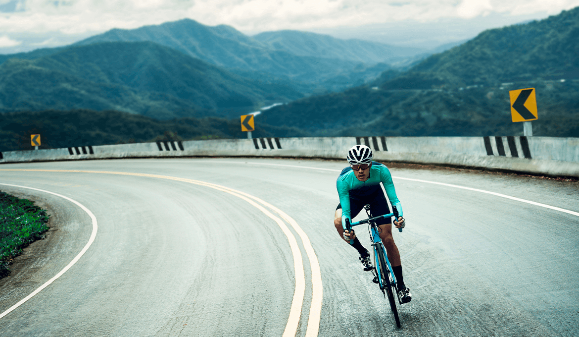 Cyclist speeding through a mountain curve, symbolizing ERP performance and reliability testing
