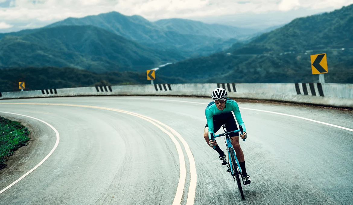 Cyclist speeding through a mountain curve, symbolizing ERP performance and reliability testing