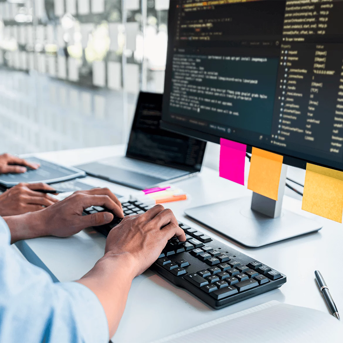 Developer typing at workstation with code on screen, illustrating test automation integration