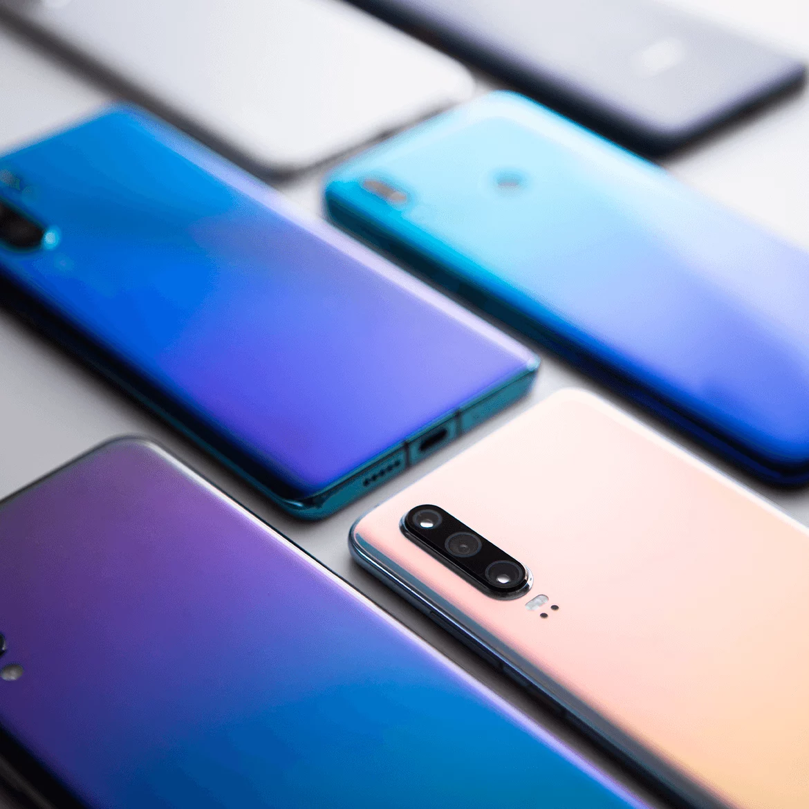 Several smartphones in different colors arranged together, representing mobile multi-platform test automation