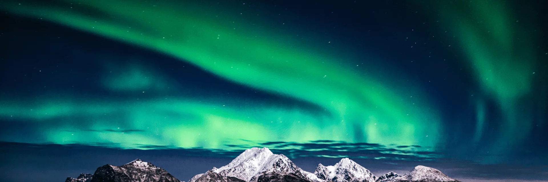 Northern lights over snow-covered mountains at night landscape