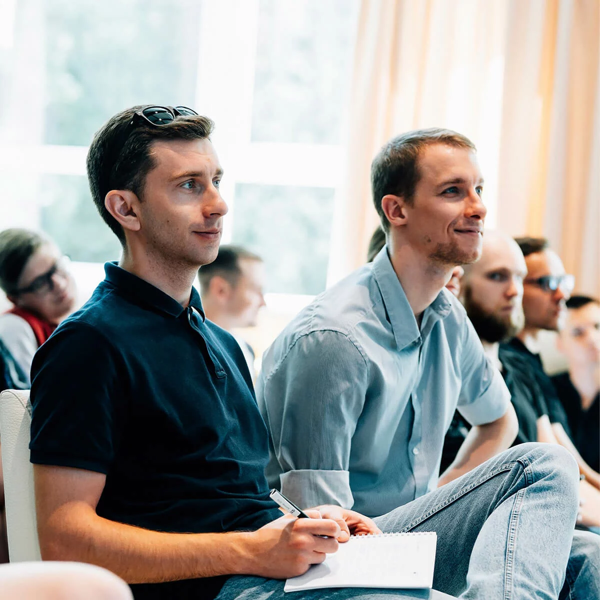 Participants attending a QA training session, listening attentively and taking notes