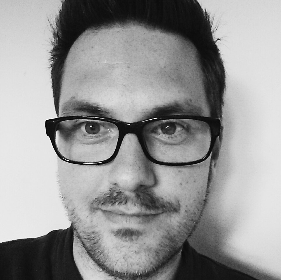 Black-and-white headshot of a man with glasses, likely software testing interview subject