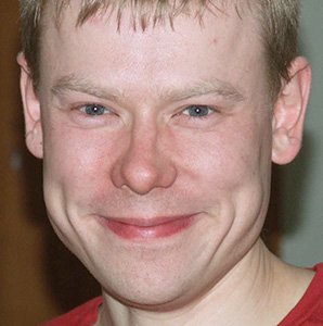 Close-up portrait of a smiling man, likely interview subject Raimond Sinivee