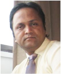 Portrait of a man in a light shirt and tie, seated indoors