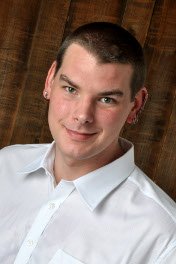 Portrait of a man in a white shirt against a wooden background