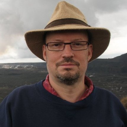 Portrait of Michael Bolton wearing a wide-brim hat and glasses outdoors