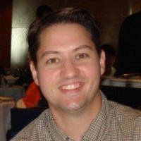 Portrait of Steve Rowe smiling indoors at a conference or networking event