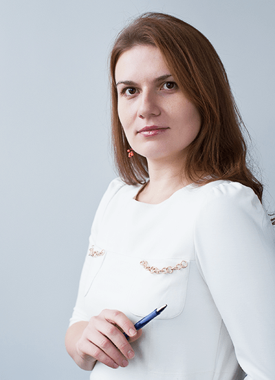 Professional woman in white blouse holding a pen, studio portrait