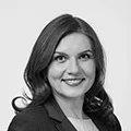 Professional headshot of a smiling woman in business attire for company profile