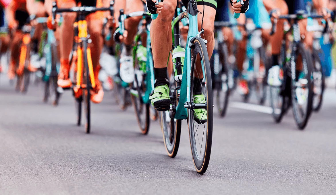 Cyclists racing closely together on a road, symbolizing speed, teamwork, and high performance