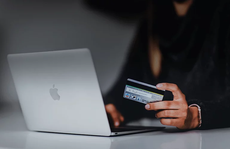 Person using a laptop and credit card for online banking or payment services