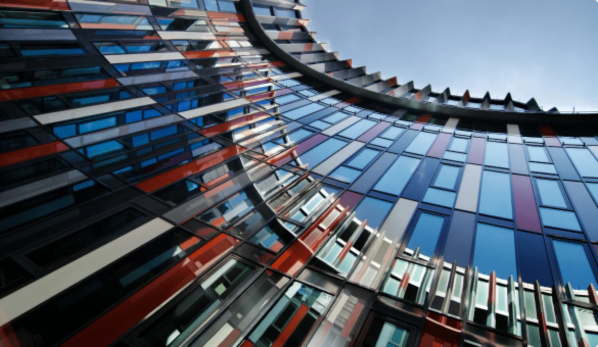 Modern curved glass office building facade symbolizing complex industry standards and compliance